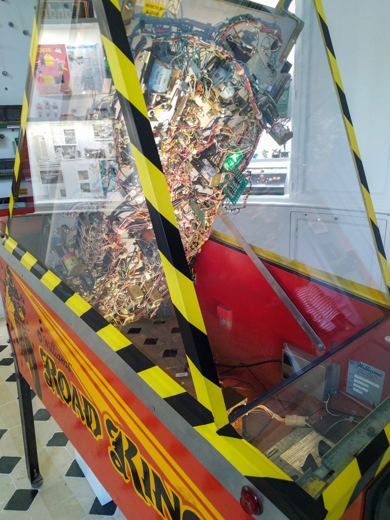 Un flipper dont le plateau de jeu est relevé, afin de voir toute la mécanique en dessous.