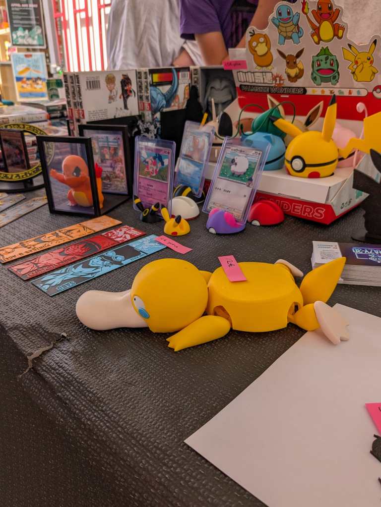 Les créations de Crazy 3Dn, dont un sous-verre Psykokwak articulé, des Pokéballs thématiques et des portes-cartes pour afficher sa collection.